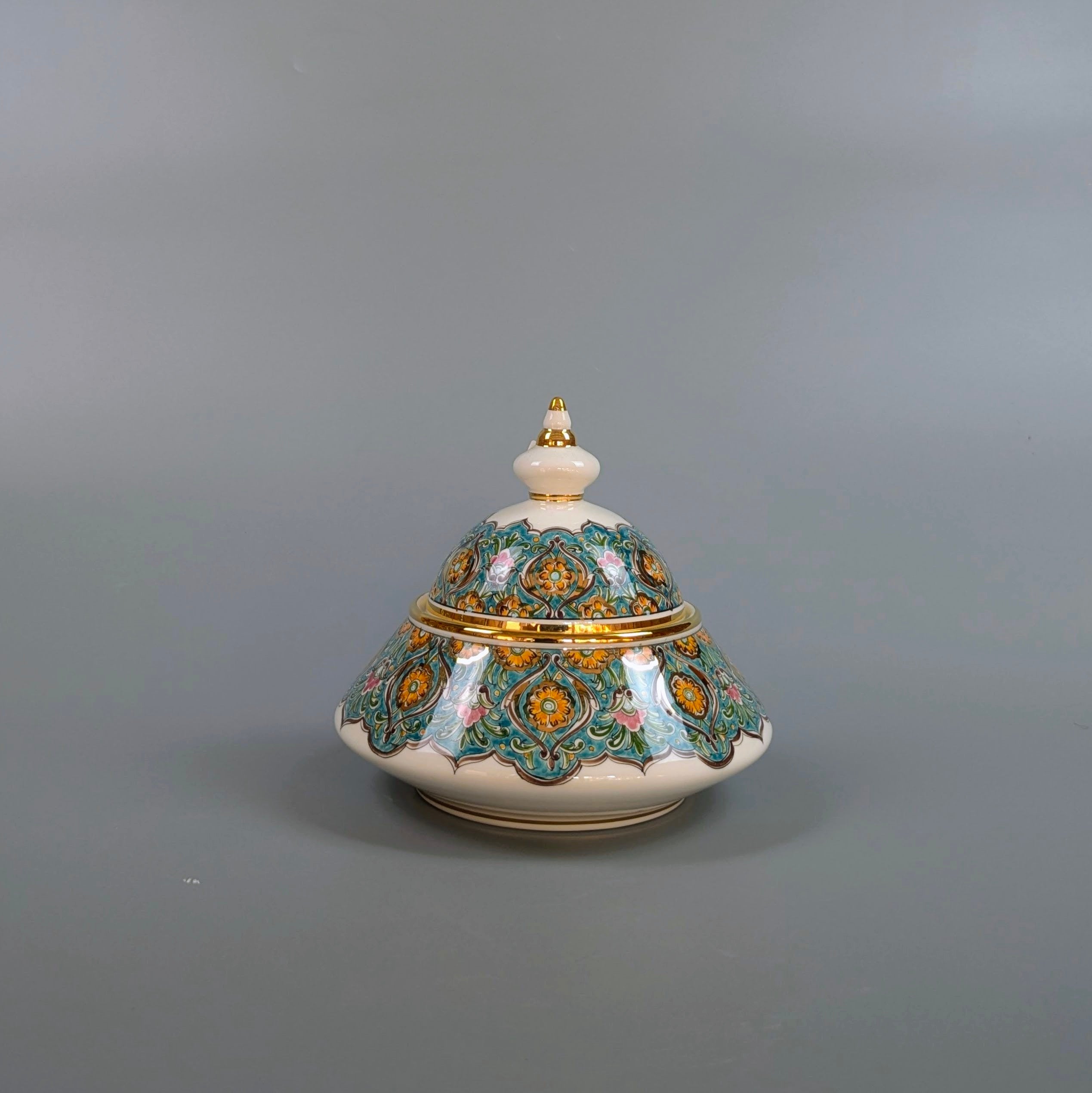 Decorative ceramic pot with intricate designs on a gray background