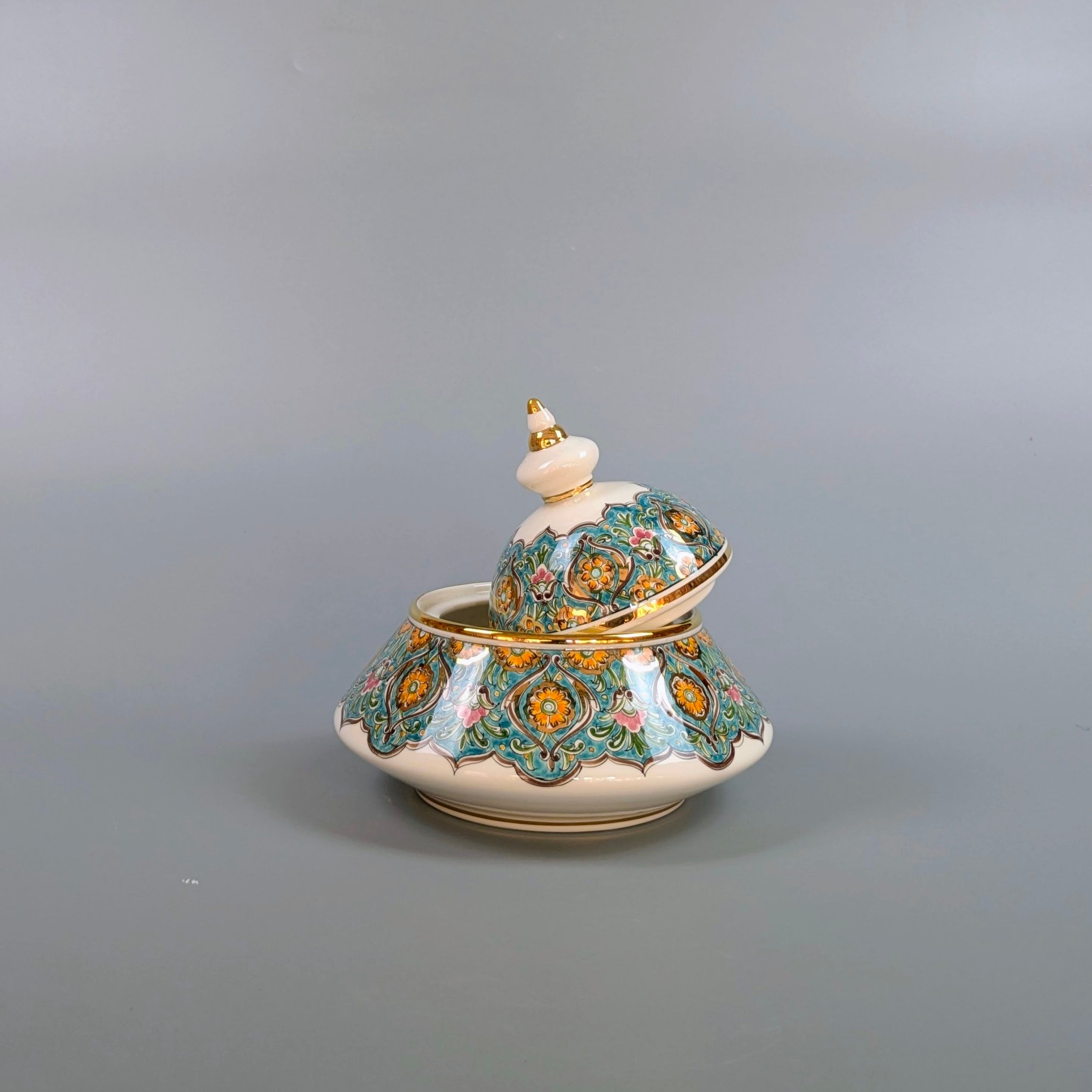 Decorative ceramic container with intricate patterns on a gray background