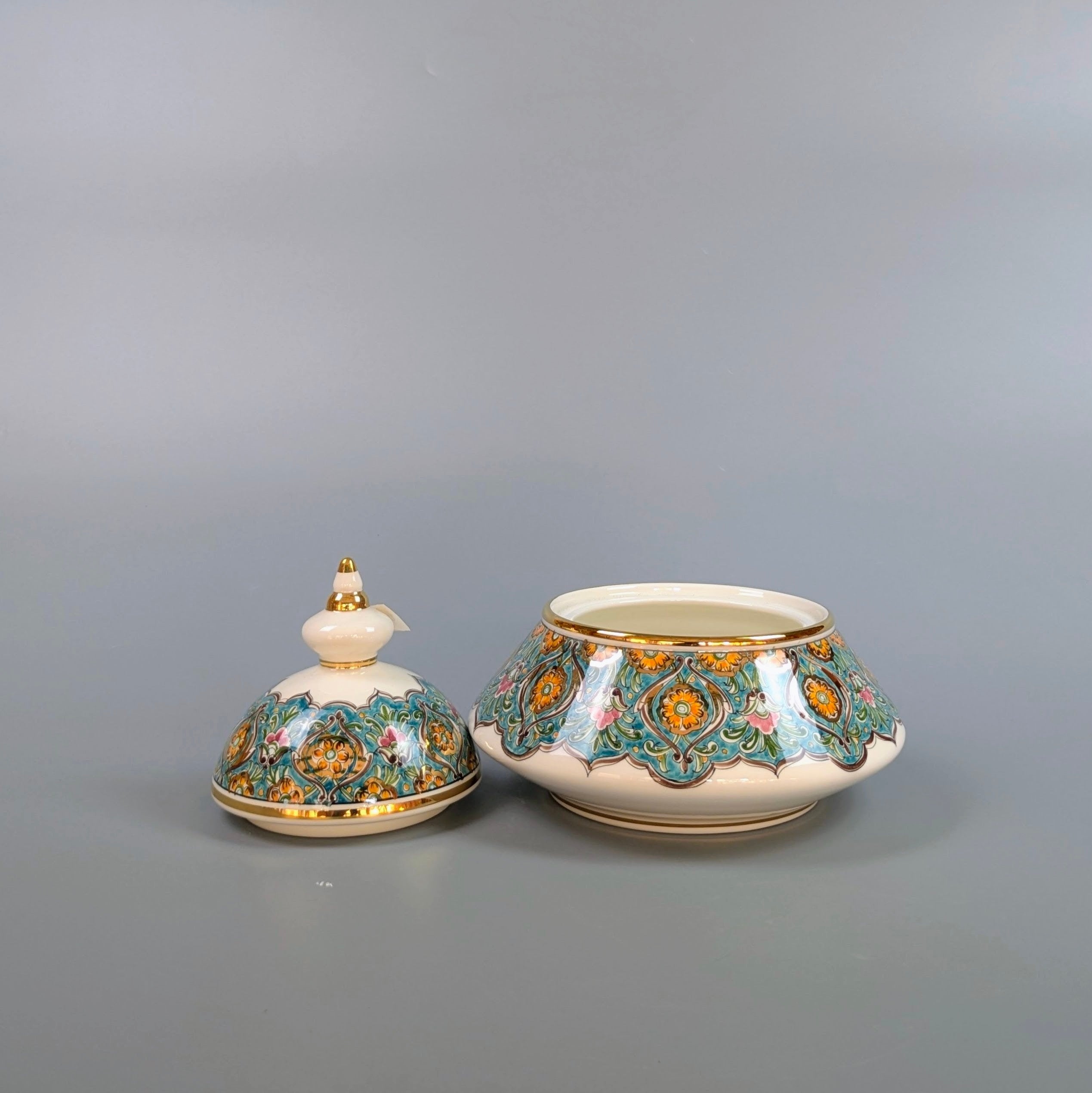 Decorative ceramic pot with lid on a gray background