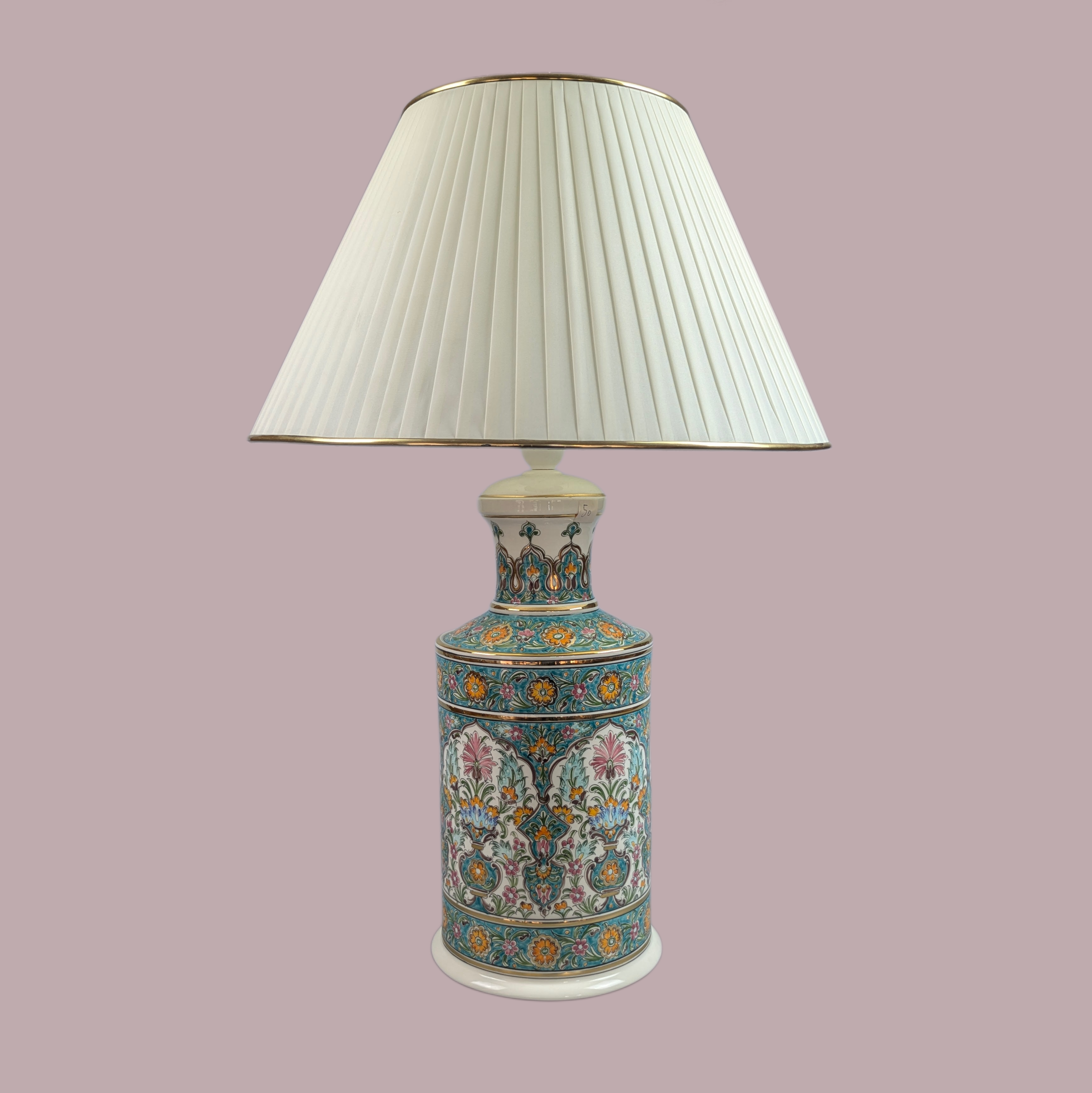 Decorative lamp with a pleated white shade on a pink background