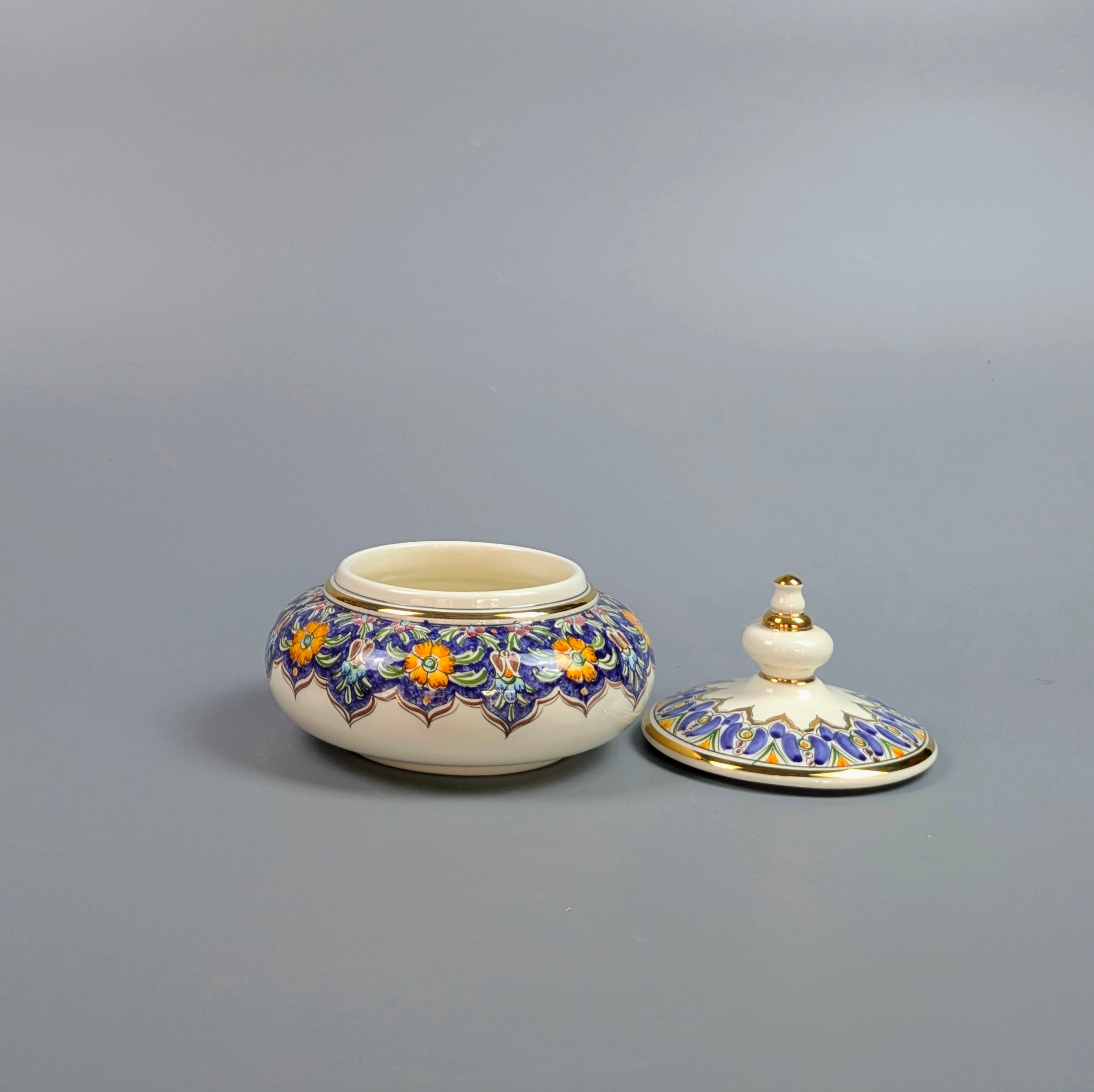 Decorative ceramic jar with floral patterns on a gray background