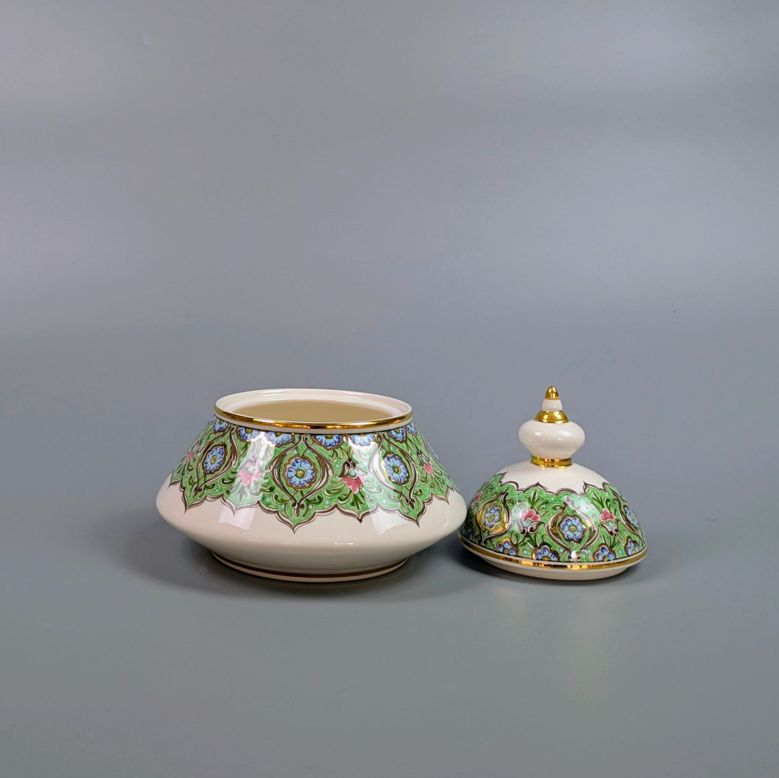 Decorative ceramic pot with lid on a gray background