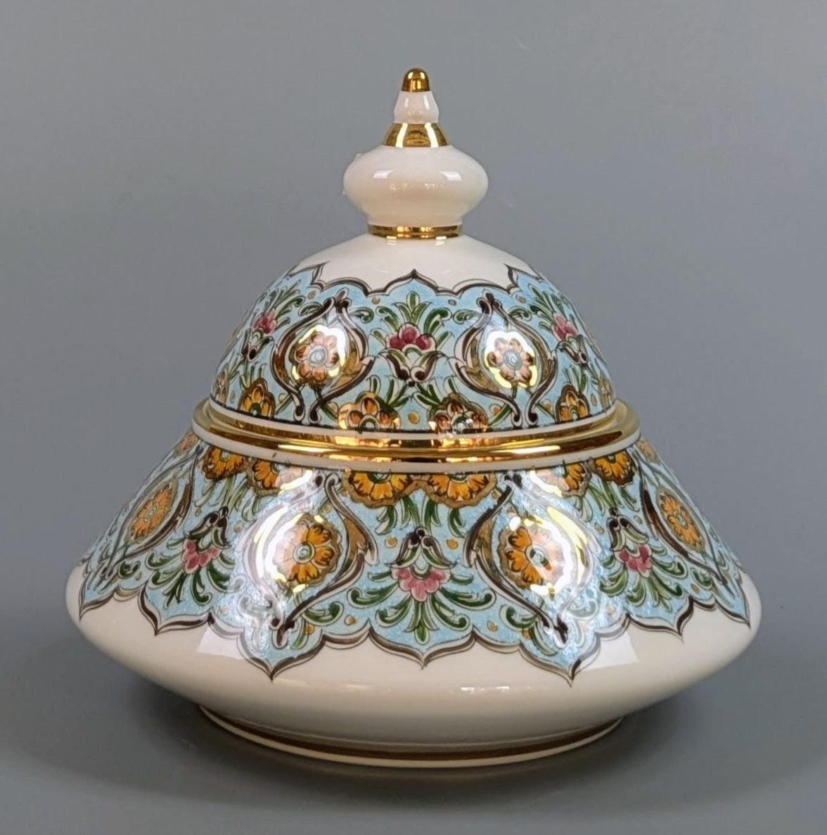 Decorative ceramic pot with intricate floral patterns on a gray background