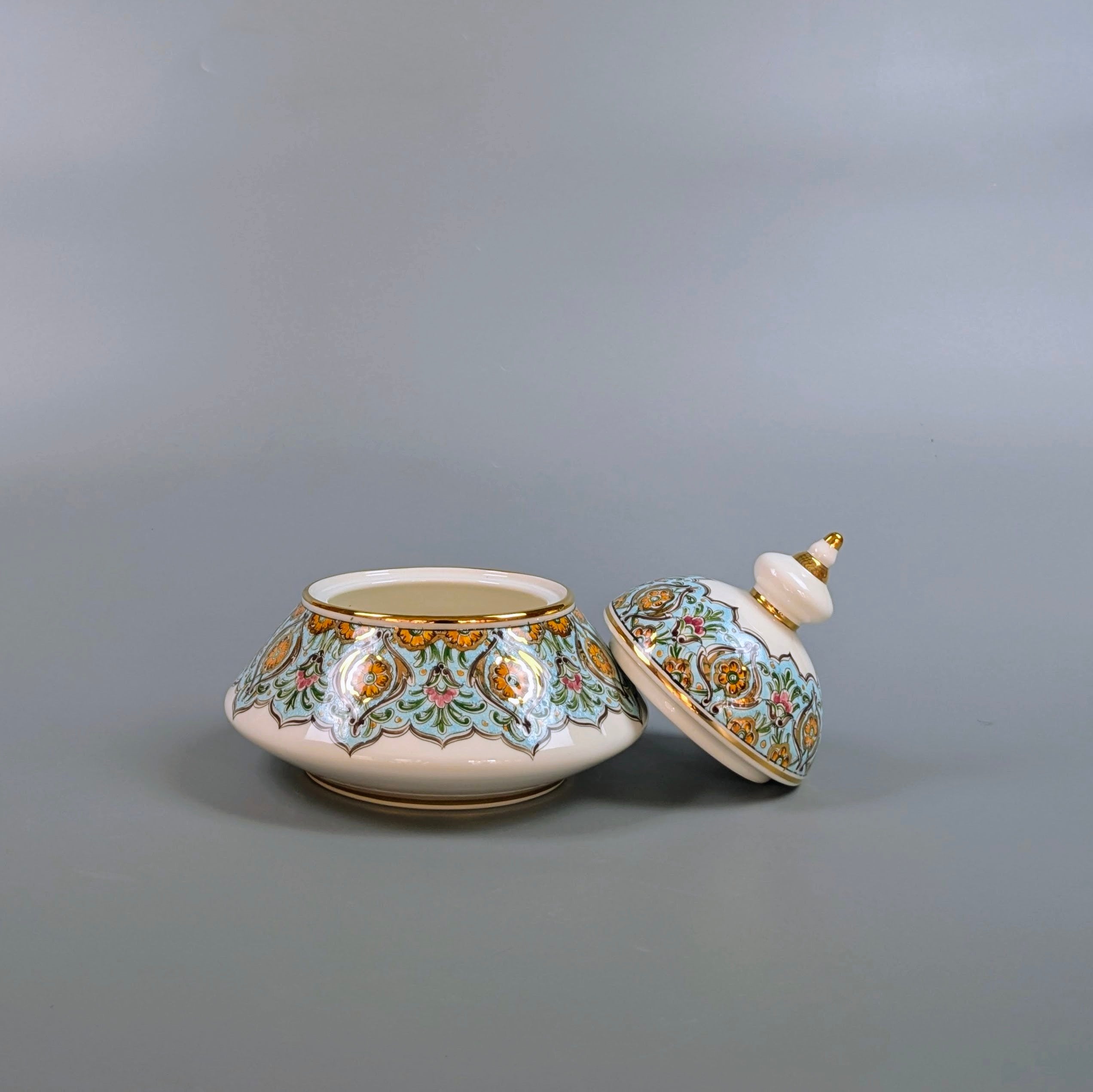 Decorative ceramic pot with lid on a gray background