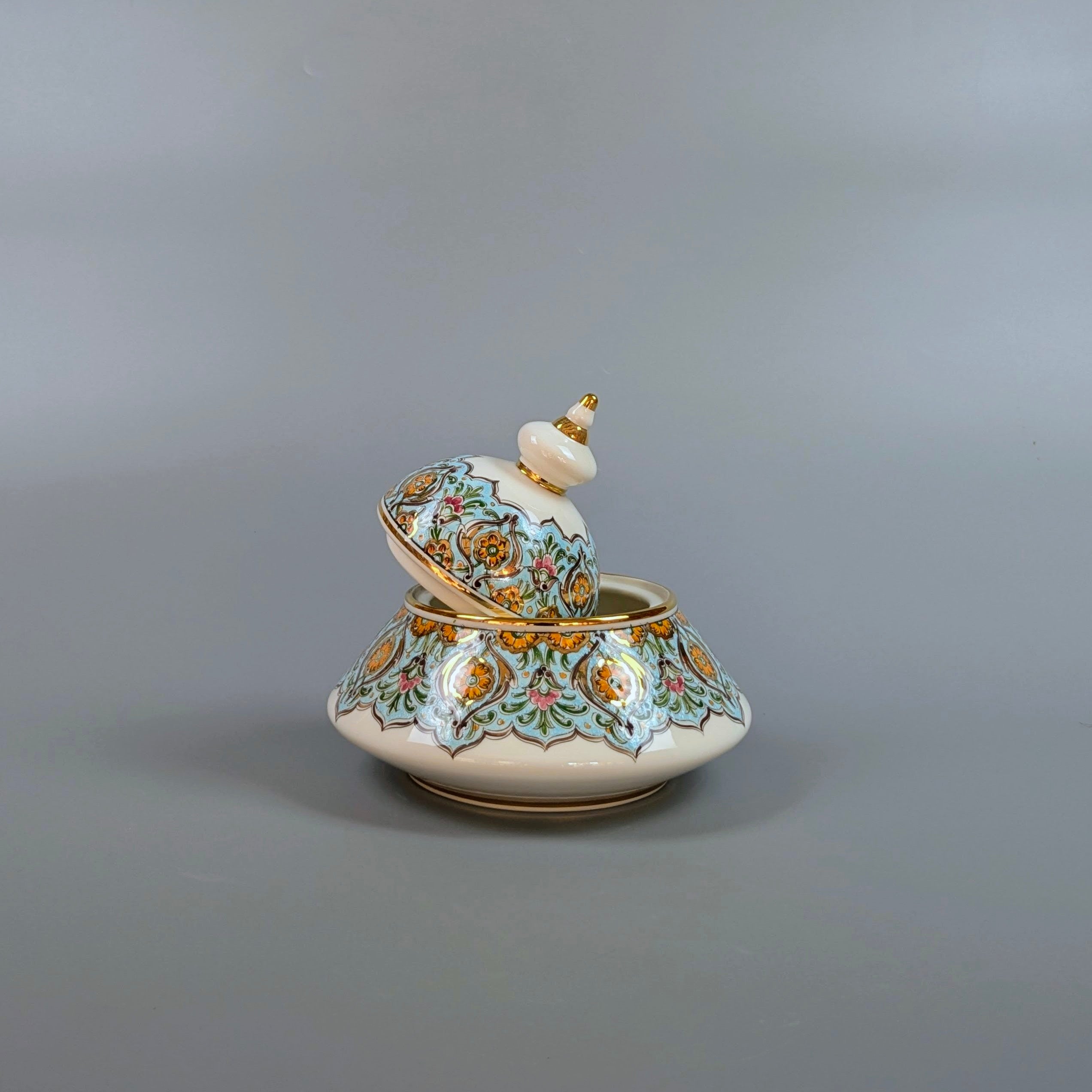 Decorative ceramic container with floral patterns on a gray background