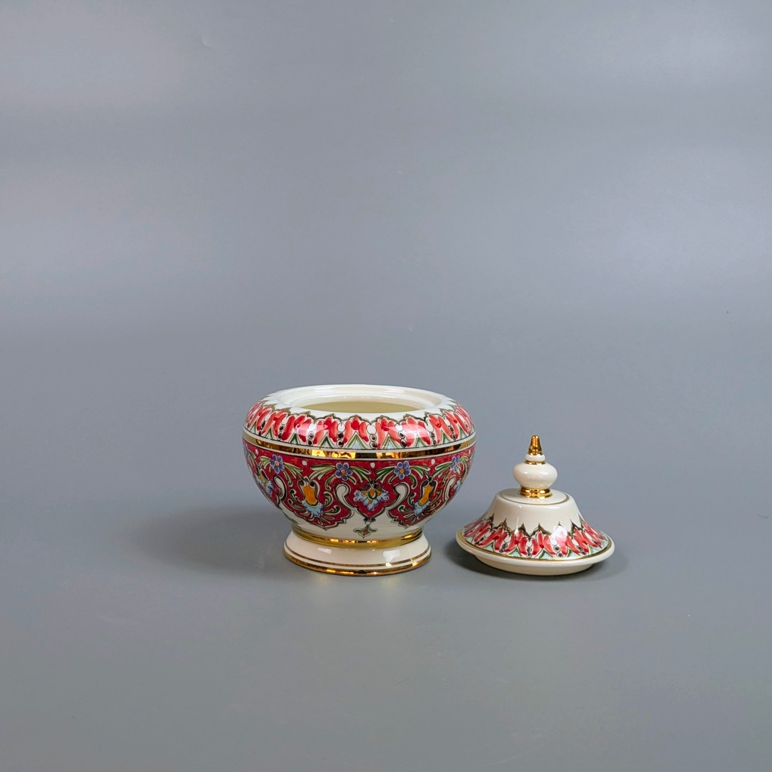 Decorative ceramic bowl with lid on a gray background