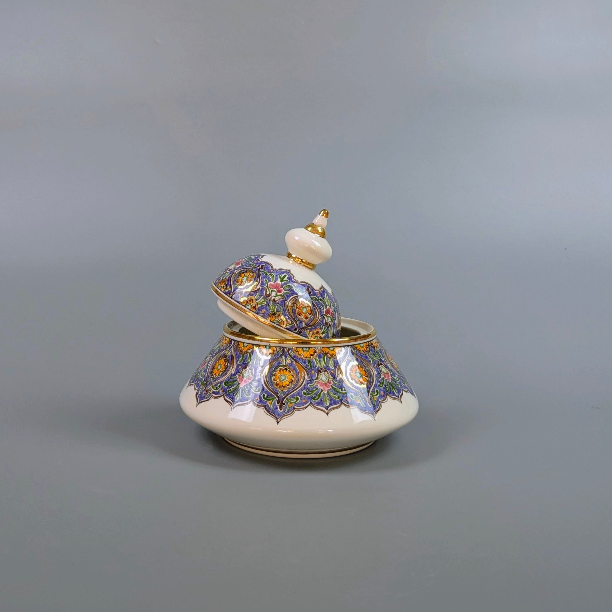 Decorative ceramic pot with a lid on a gray background