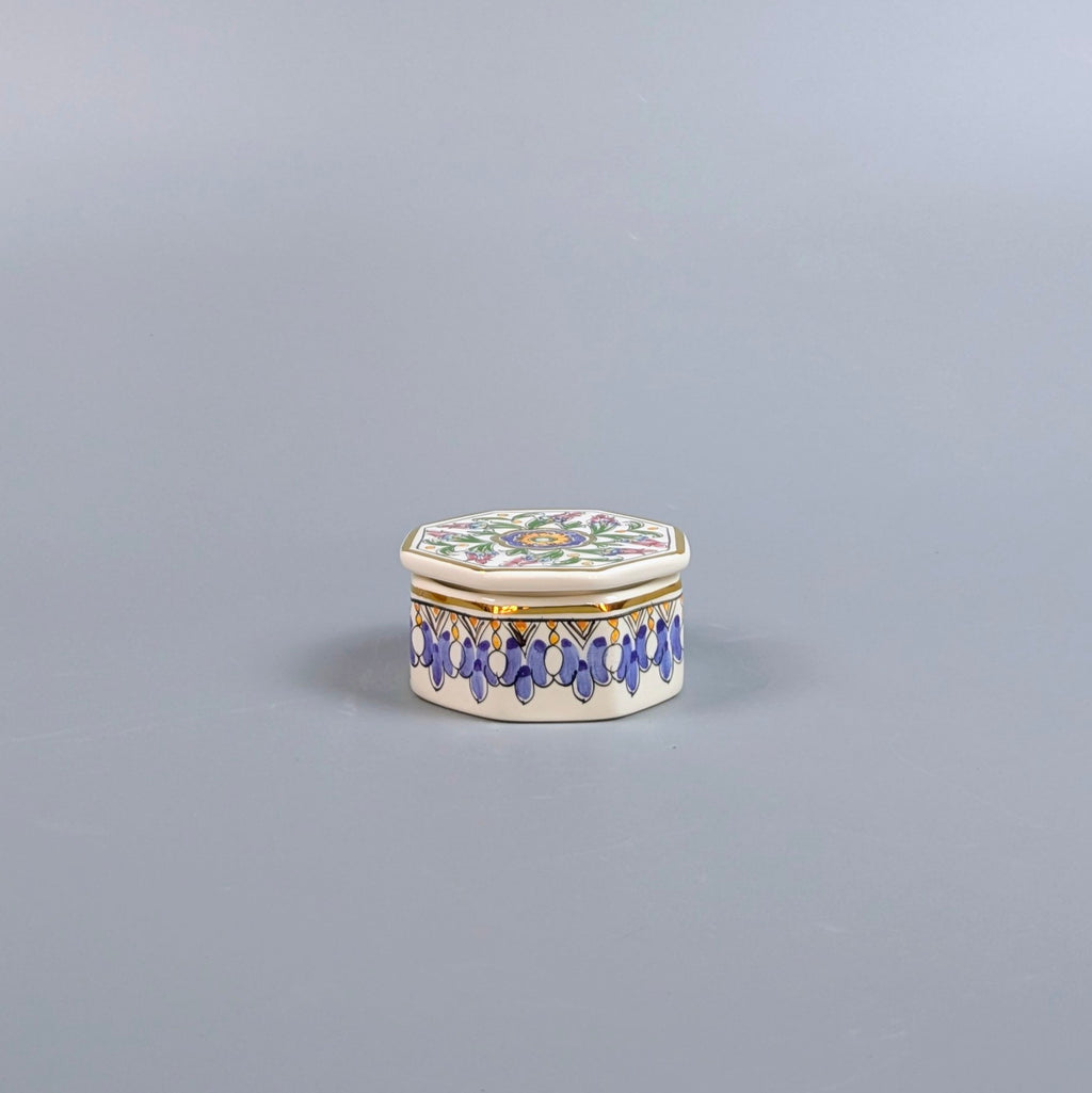 Decorative hexagonal box with floral design and blue accents on a gray background