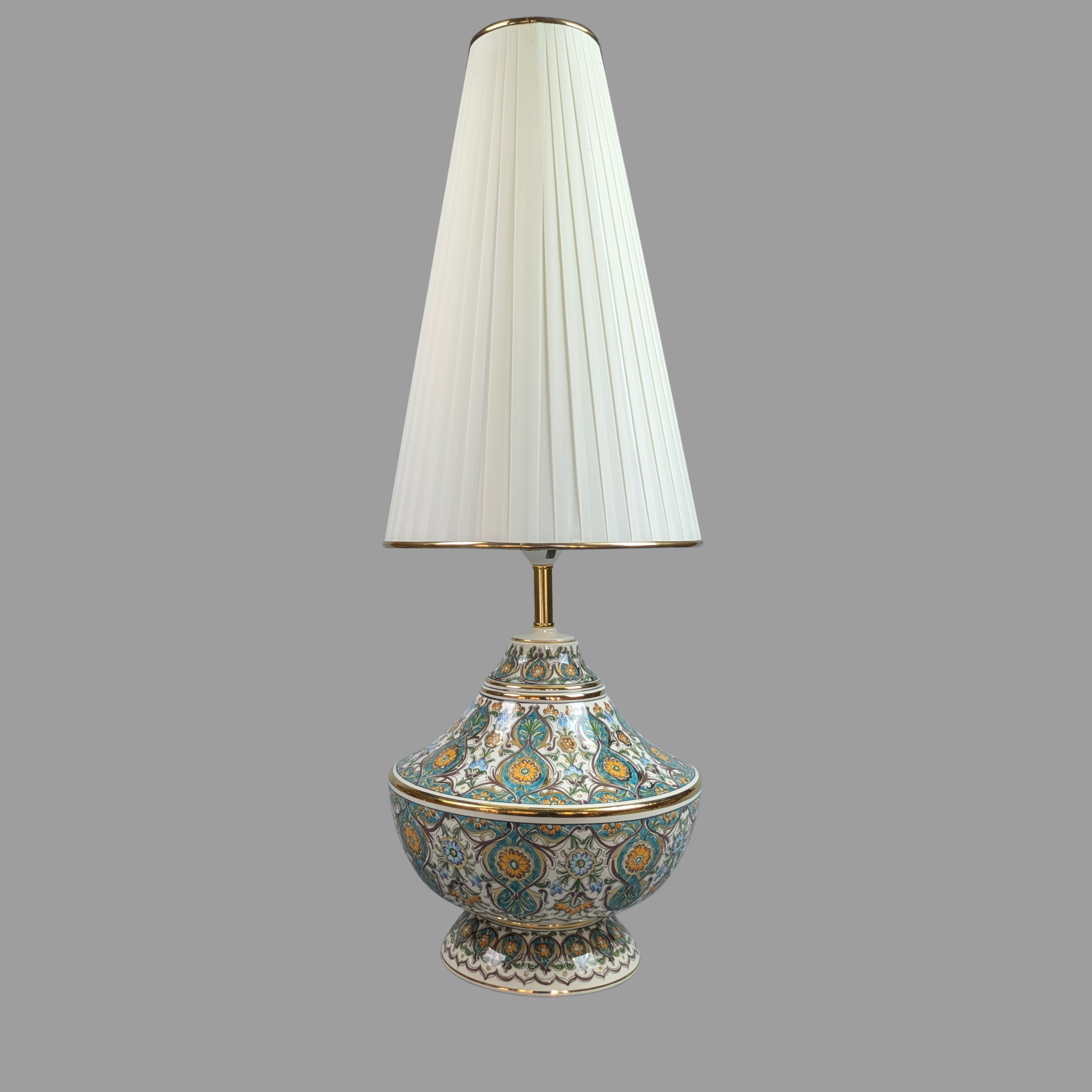 Decorative table lamp with a white pleated shade on a gray background
