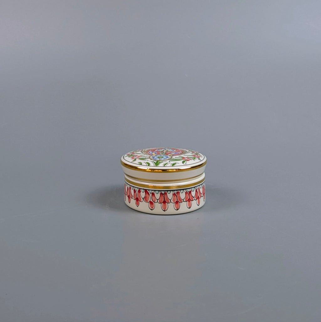 Decorative ceramic jar with floral design on a gray background