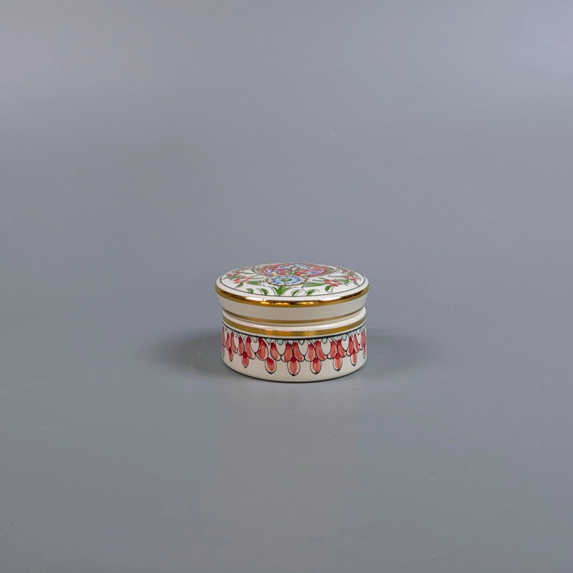 Decorative ceramic jar with floral design on a gray background