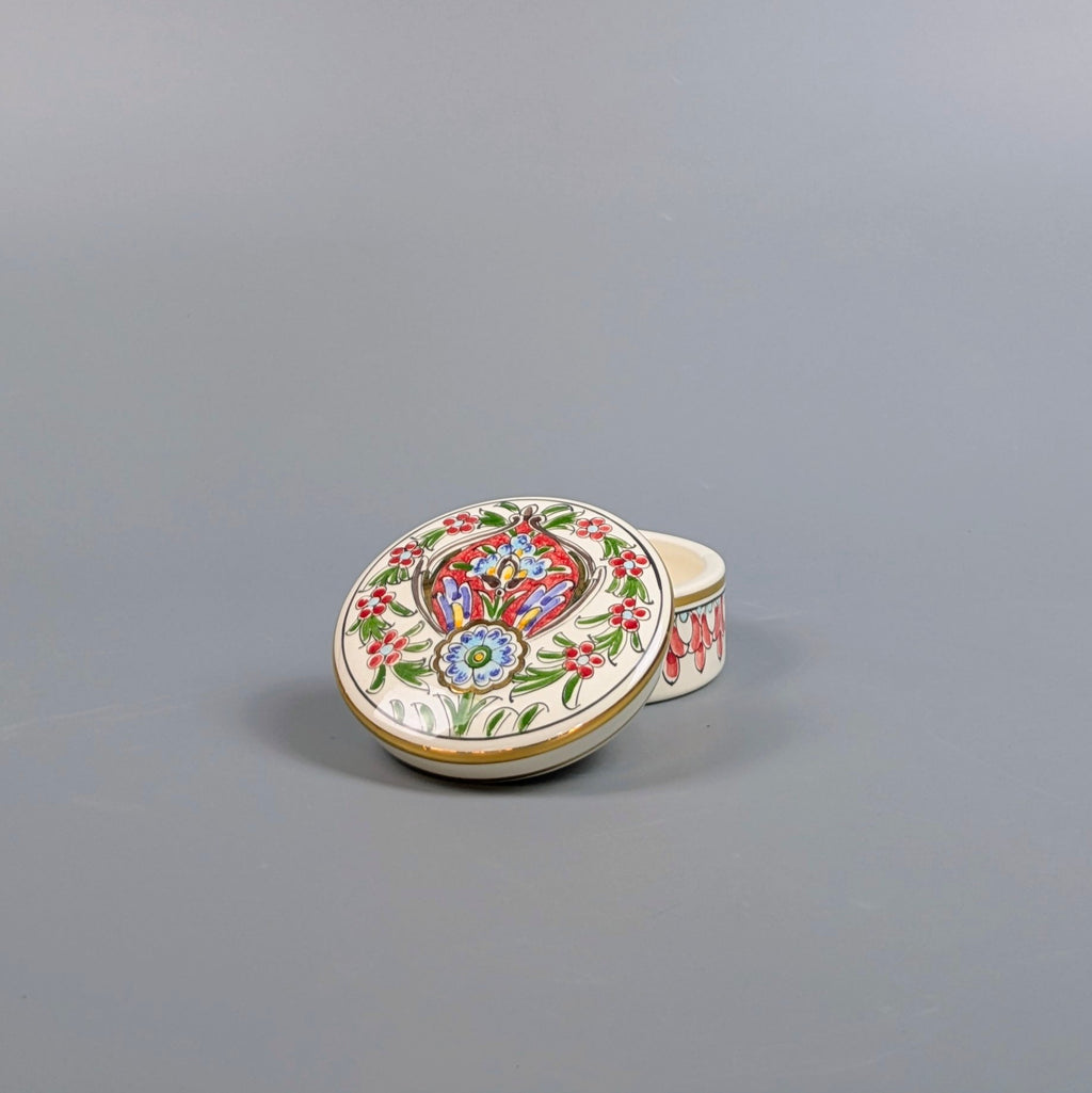 Decorative ceramic box with colorful floral design on a gray background