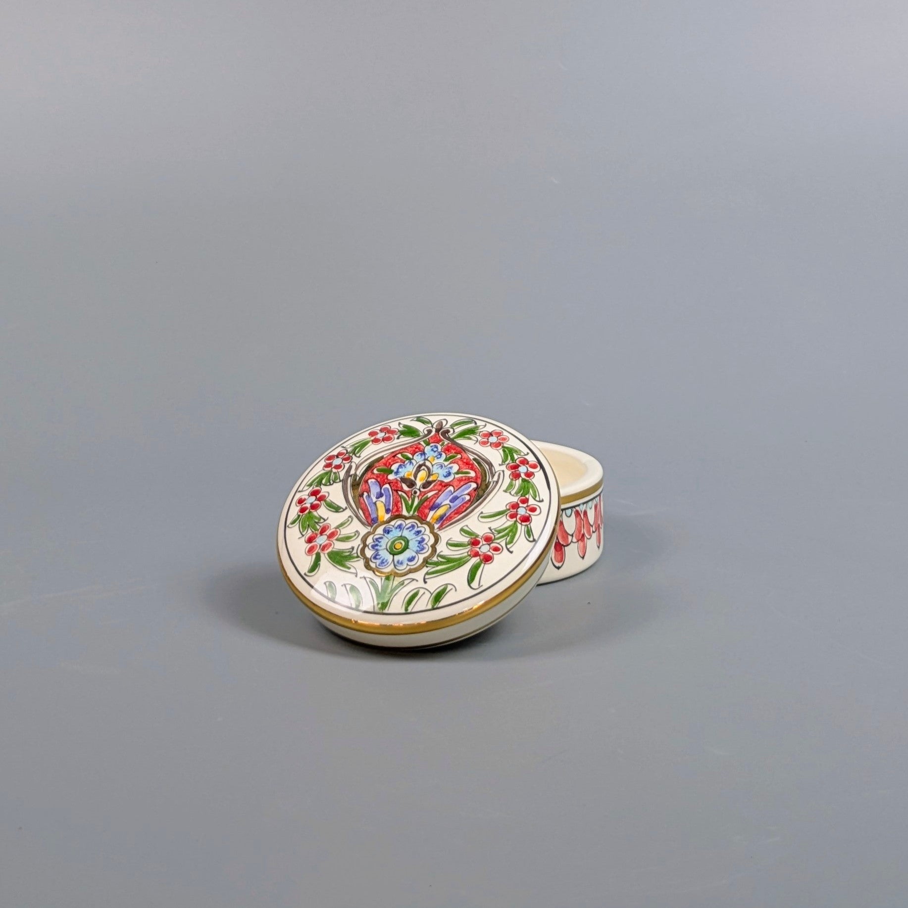 Decorative ceramic box with colorful floral design on a gray background