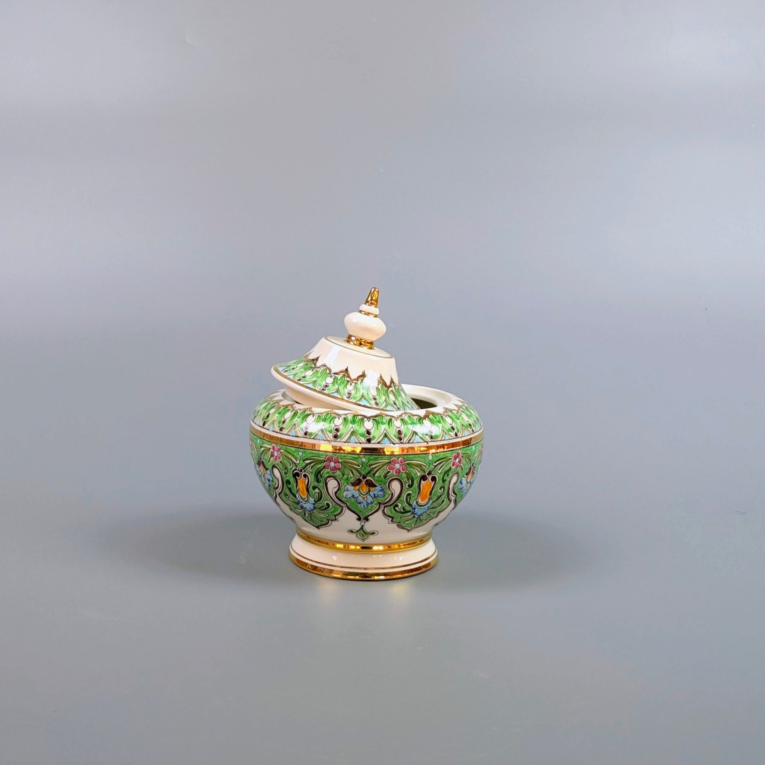 Decorative ceramic pot with a lid on a gray background