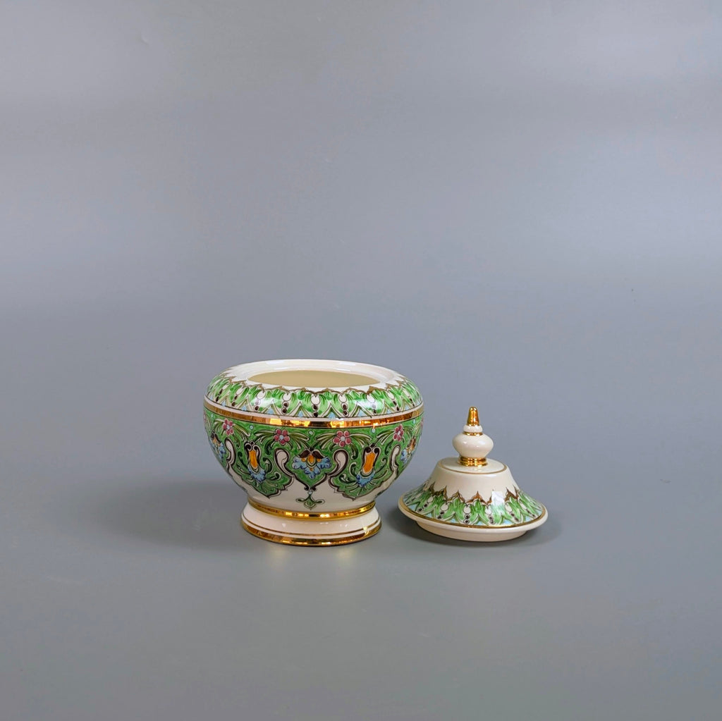 Decorative ceramic bowl with lid on a gray background
