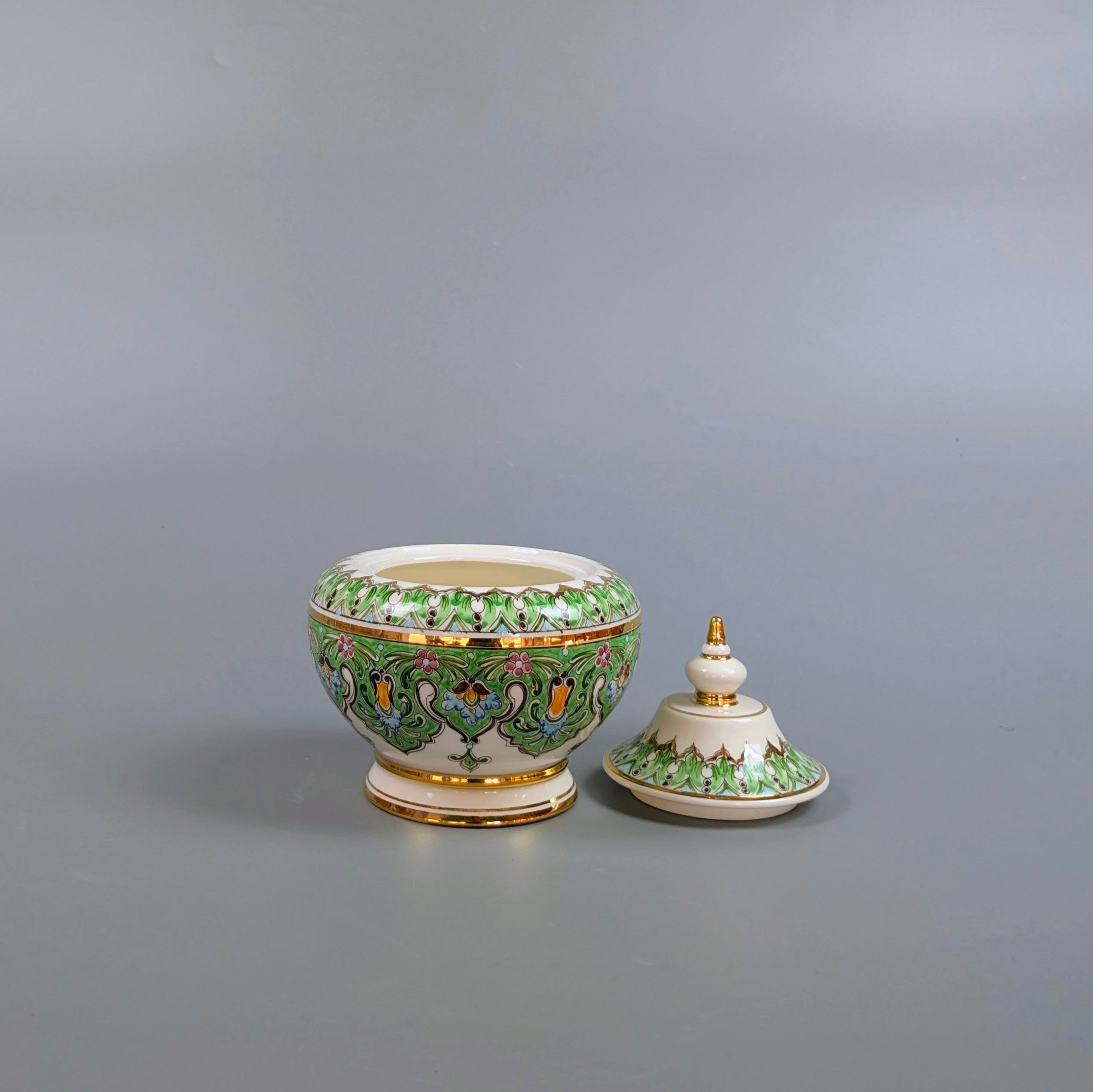 Decorative ceramic bowl with lid on a gray background