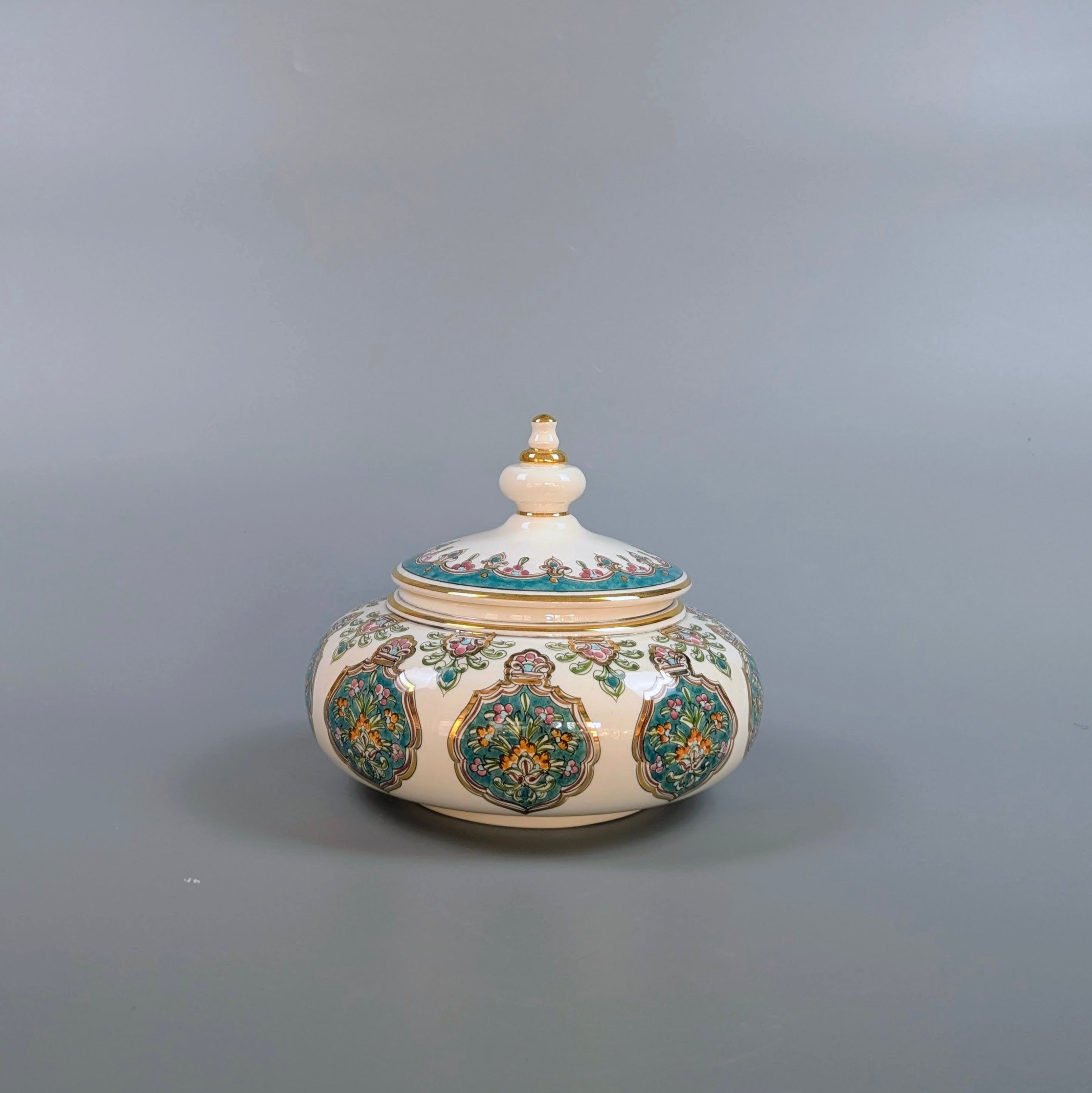Decorative ceramic jar with a lid on a gray background