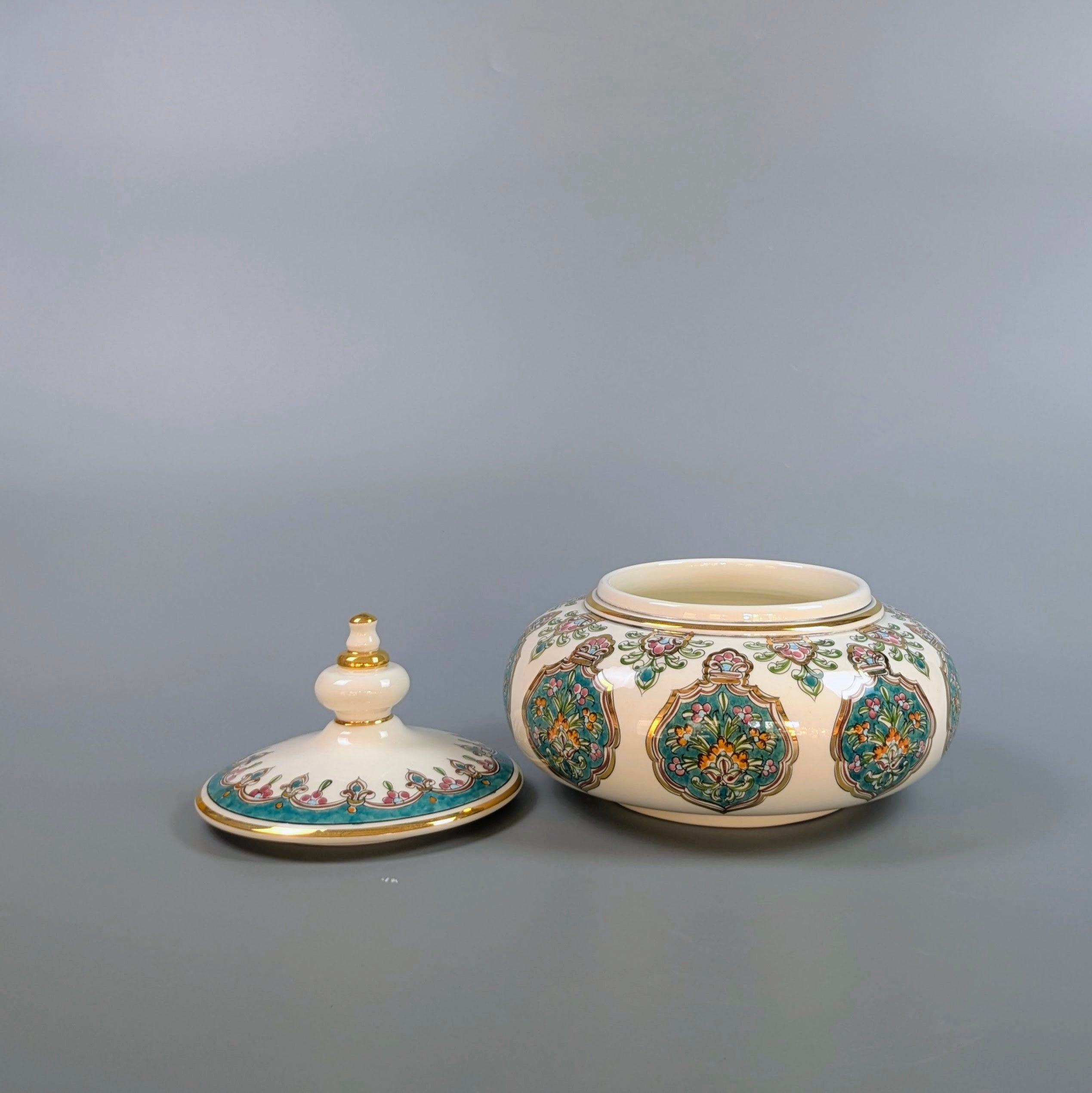 Decorative ceramic jar with lid on a gray background