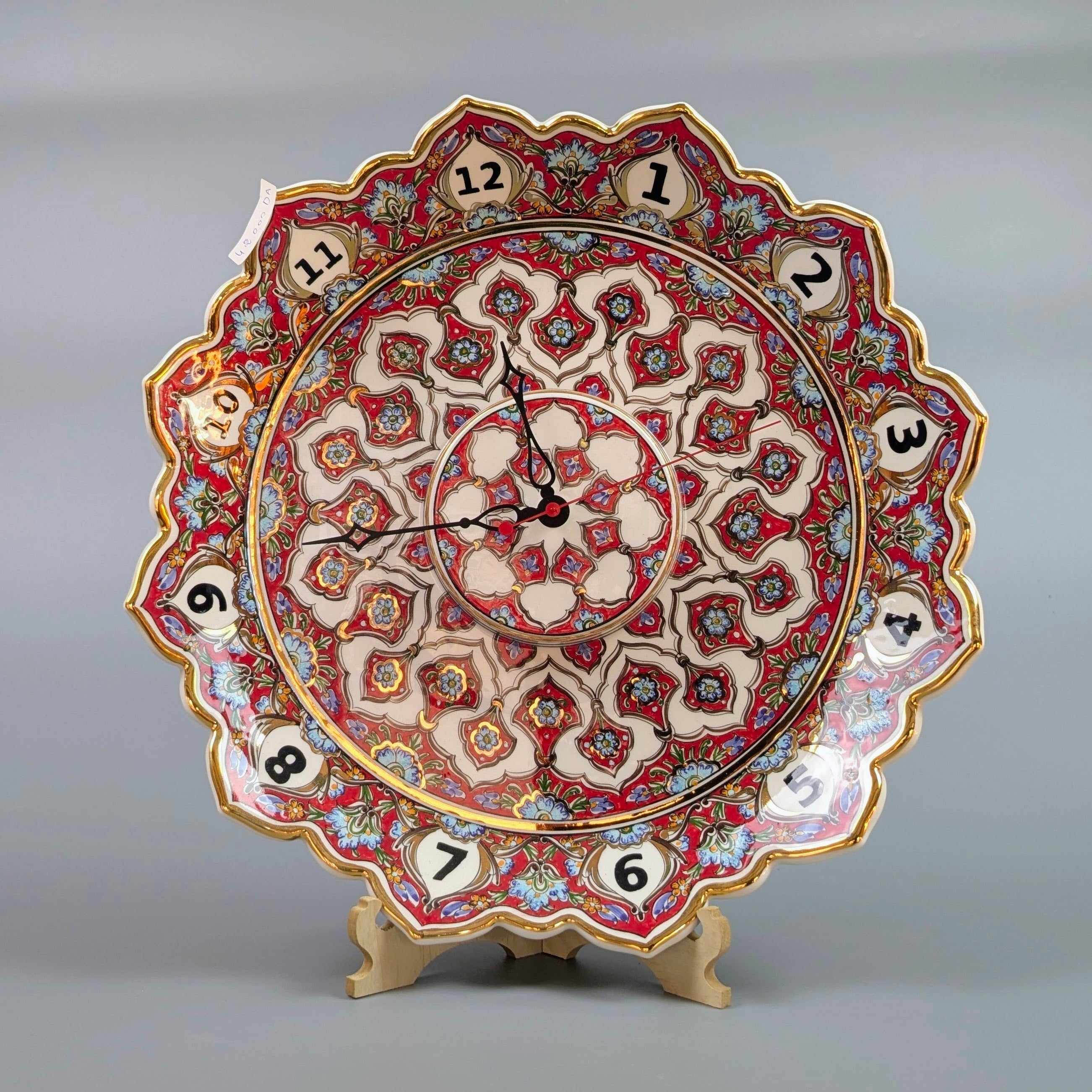 Decorative wall clock with intricate patterns on a gray background